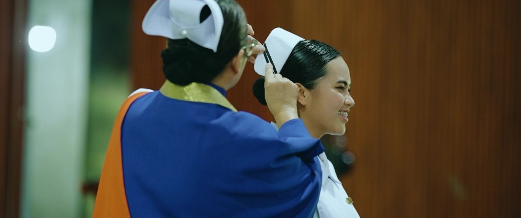 A Nursing student receives her cap during the striping ceremony