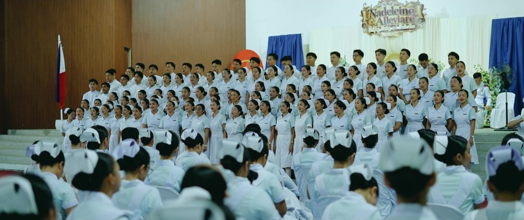 Nursing students sing on stage during the Striping, Pinning, and Dedication Ceremony
