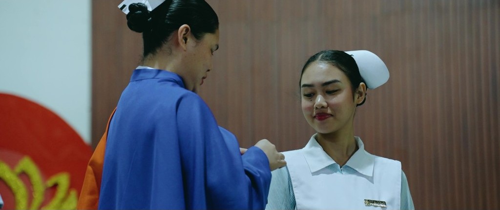 A faculty member pins a Nursing student during the dedication ceremony
